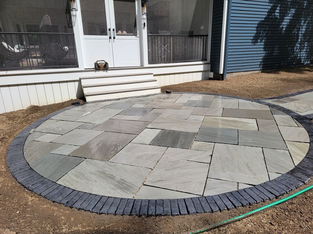 Circular bluestone patio ringed with a charcoal soldier course