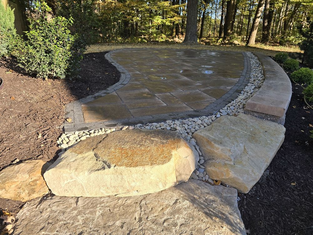 Irregular flagstone patio with river rock border and boulder steps