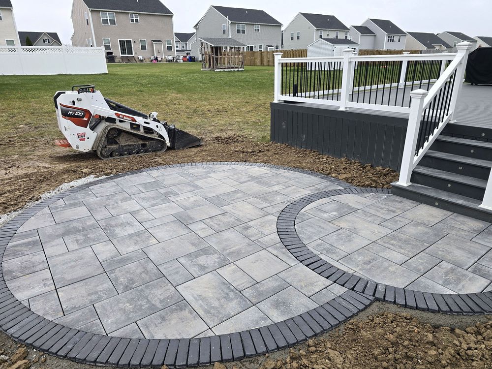 Two interlocking paver circles with charcoal borders at the foot of a deck