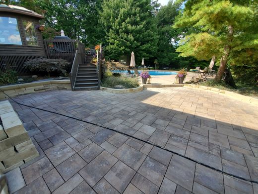 After: paver terrace with sandstone seat walls running to the pool