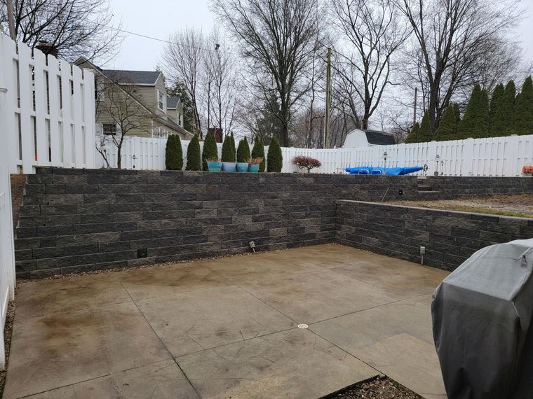 Sunken patio enclosed by a charcoal block retaining wall