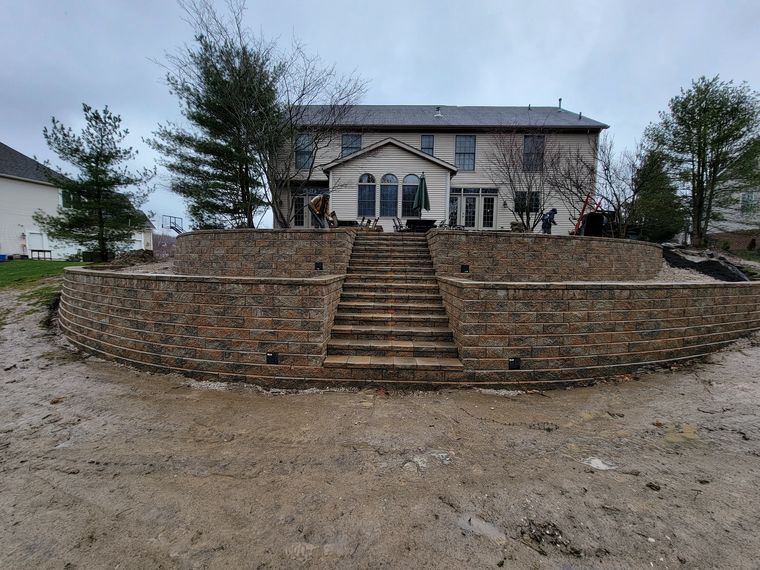 Curved double-tier block retaining wall with a central staircase