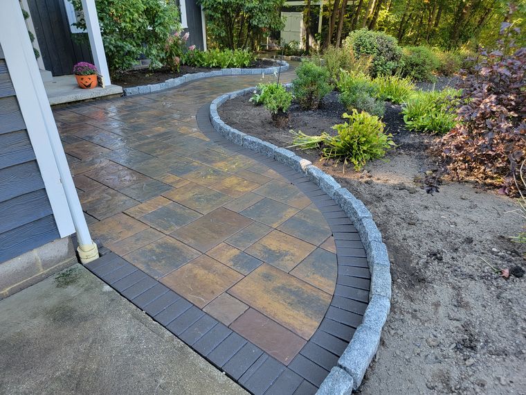 Paver walk with a cobble-look curved border and new plantings alongside